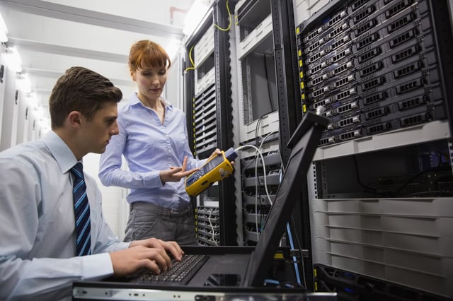 Team of technicians using digital cable analyser on servers in large data center.jpeg